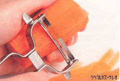 金属製のピーラーを押し当て手前に引き、人参を薄くむいている様子の写真