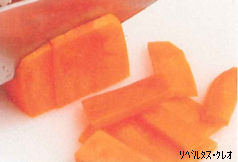 オレンジ色の人参を包丁で薄く短冊切りにしている様子の写真