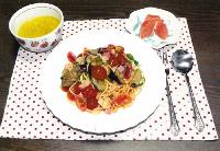 具沢山のスパゲティと、左上にかぼちゃのスープ、右上に赤いグレープフルーツが並ぶ写真