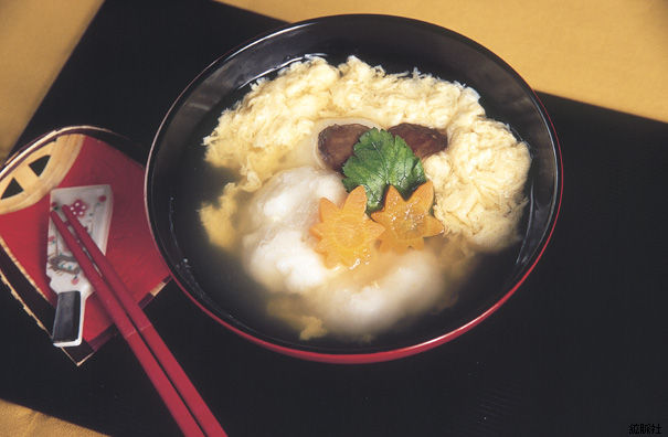 ふわふわの卵、紅葉の形に型抜きされた人参、三つ葉、椎茸が美しく添えられソフト餅入り雑煮の写真