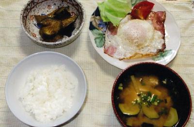 ご飯が入った茶碗から時計回りになすのみそ炒め、ハムエッグ、ズッキーニの味噌汁が並べられている写真