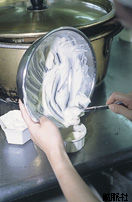 ボウルで混ぜた材料を容器に入れている写真