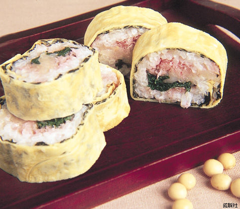 薄焼き卵で巻かれた太巻きの寿司が切り分けて盛られ彩り豊かな具材が見えるたまご巻きの写真