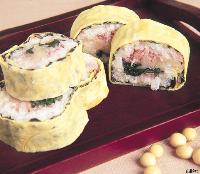 薄焼き卵で巻かれた太巻きの寿司が切り分けて盛られ彩り豊かな具材が見えるたまご巻きの写真