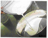 ボールで混ぜた材料をこし器に流し込んでいる写真