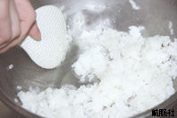 ボウルに入れたご飯をしゃもじを使って切るように混ぜている写真