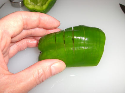 縦に切り、ヘタと種を取ったピーマンに隠し包丁を入れた写真