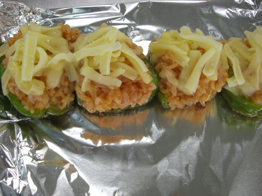 ライスを詰めたピーマンをアルミホイルに置き、その上にチーズをのせている写真