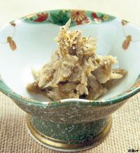 白味噌風の和え衣で束ねた細切りのごぼうがこんもり盛られ胡麻が散らされた、たたきごぼう風の写真