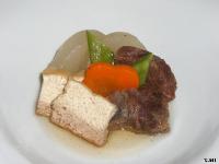 淡い煮汁に浸され人参や絹さやが添えられ彩りよく盛られた牛スジと厚揚げの炊き合わせの写真