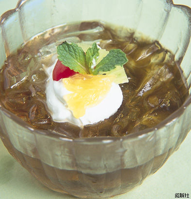 上にホイップと甘夏みかんとチェリー、ミントが添えられた琥珀色をした葛切り風の写真