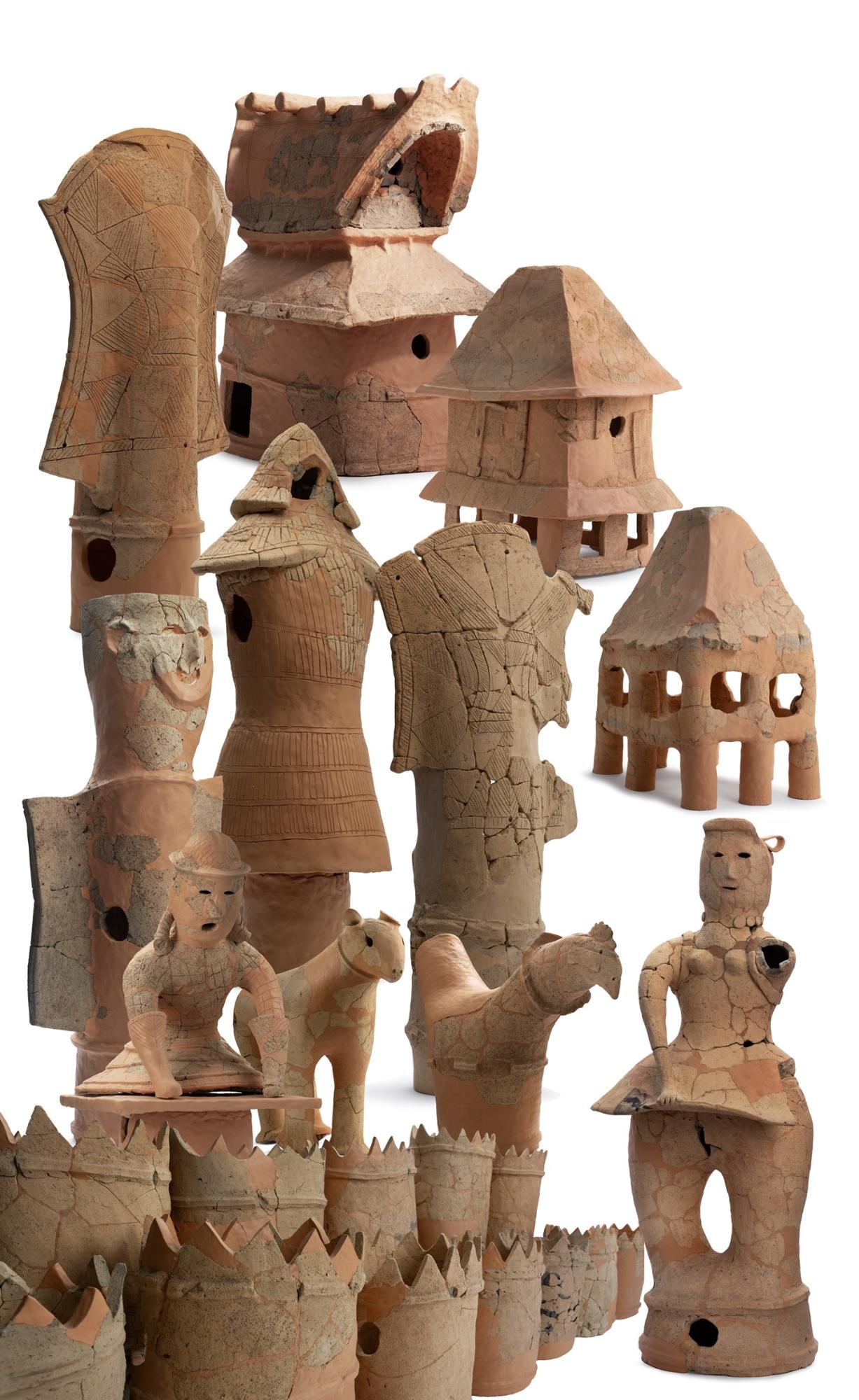 家や盾の形をしたものから、盾を持つ人や馬、鶏などの動物、そして装飾を身に着けた女性などを象った大小様々な種類の埴輪が並べられている写真